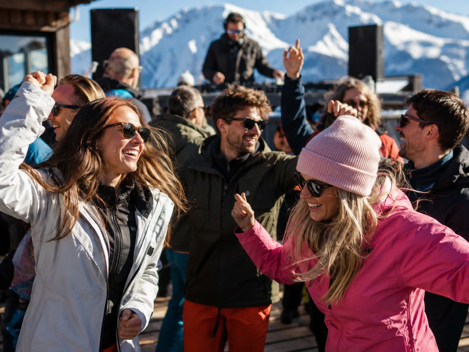 Gruppe tanzt ausgelassen auf einer Bergbar-Terrasse