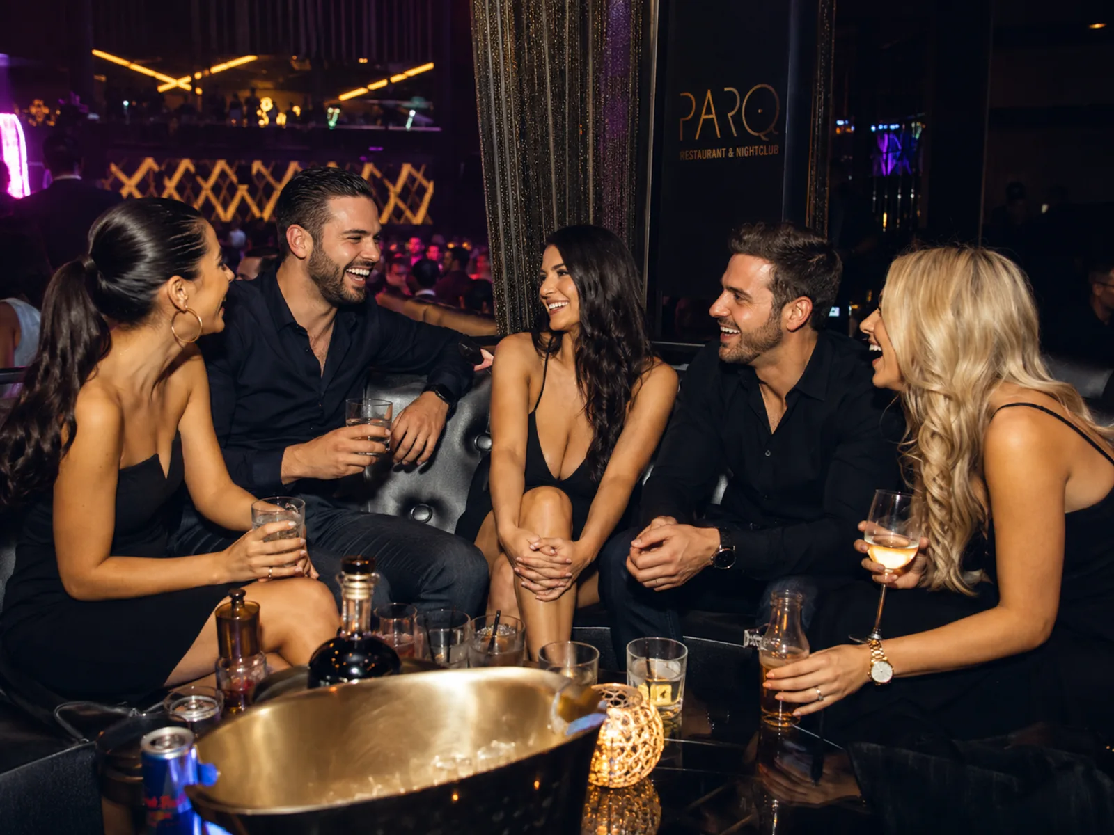 Freunde sitzen lachend in einer VIP-Lounge-Ecke
